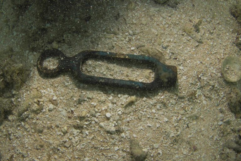 An iron fitting lying on the seabed