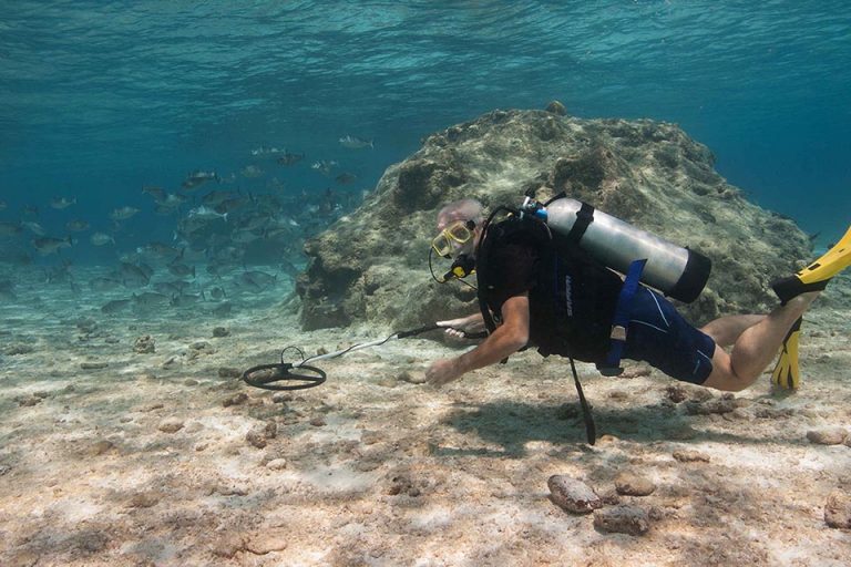 A diver searching with an underwater metal detector