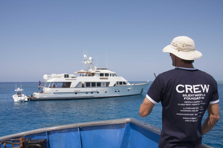 A crew member watching the expedition vessel from a small boat