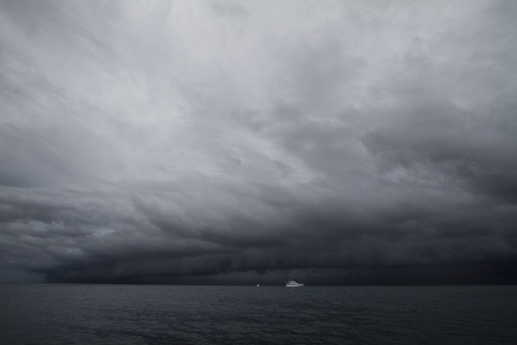 Dark storm clouds over the sea and the research vessel