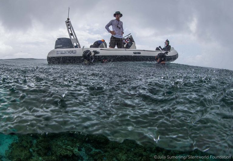 The team searching in the rain from a small boat